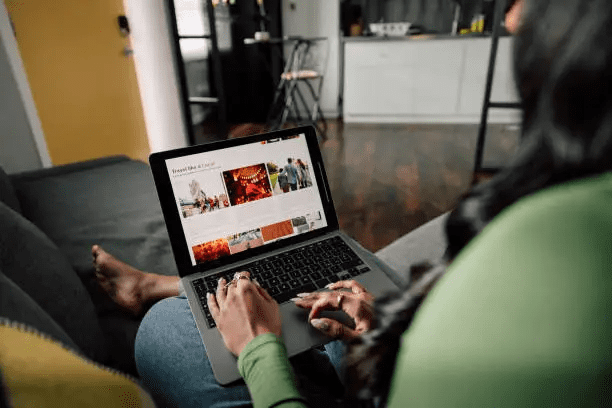 Person using laptop on a couch.