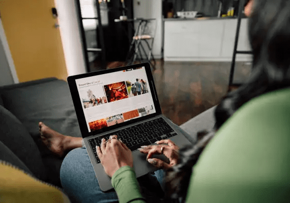 Person using laptop on a couch.